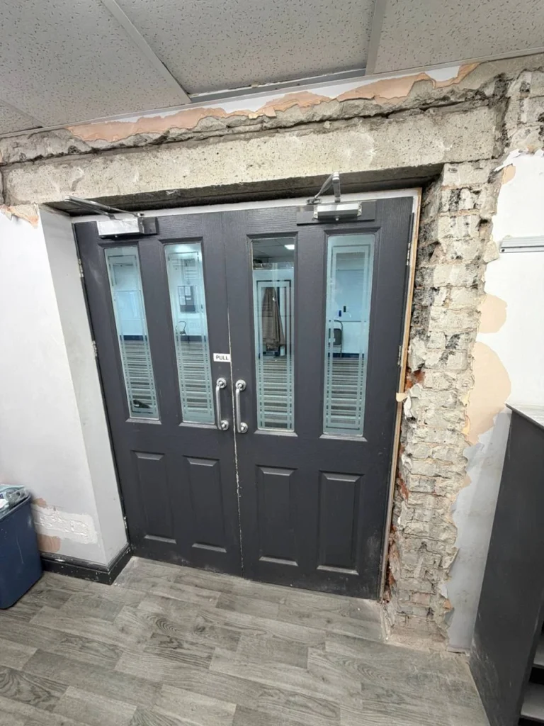 Masonry exposed around the original entrance doors.