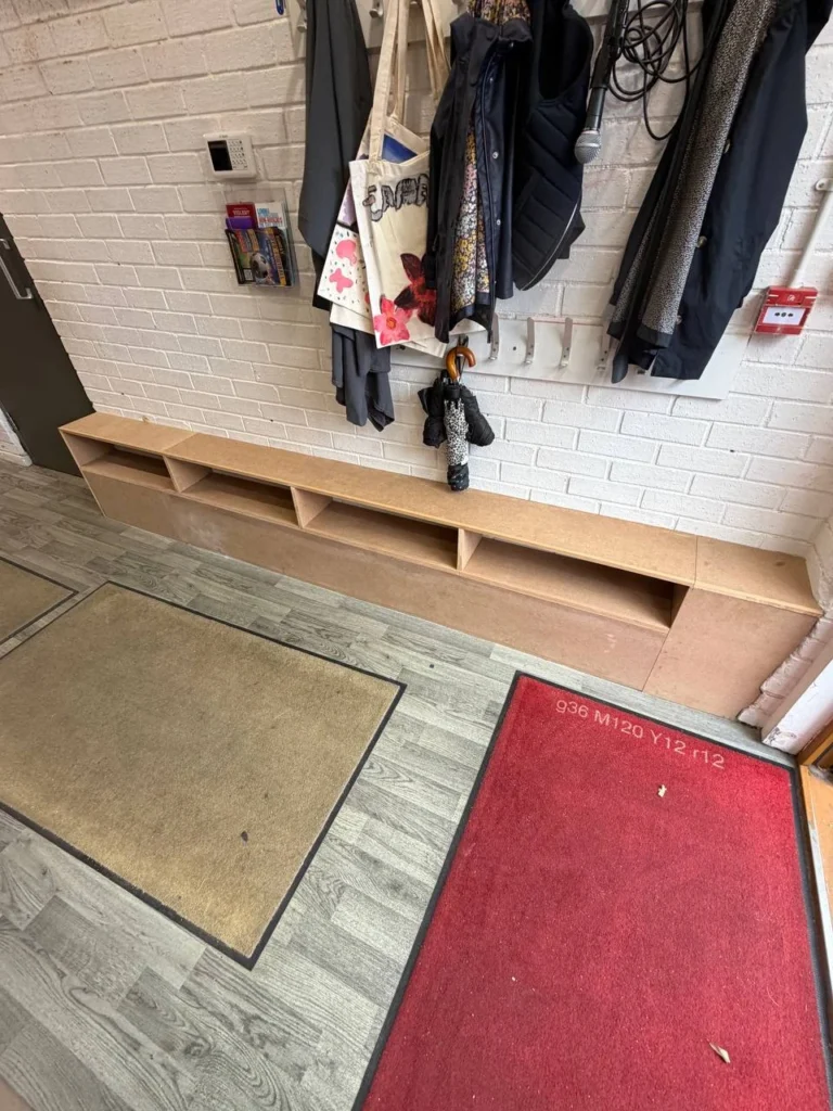 Low storage and boxing beneath the coat hooks.