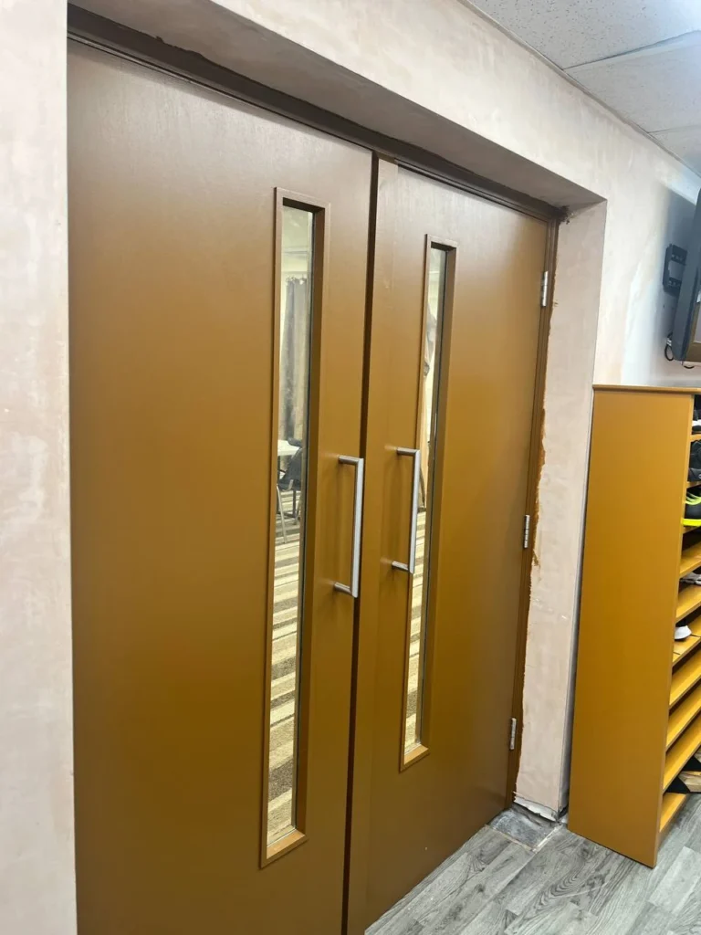 Painted entrance doors viewed from the corridor.